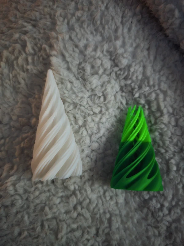 Cone-shaped Christmas fidget spinner with green and white spiral design, placed on soft textured fabric—festive sensory toy for holiday gifting.