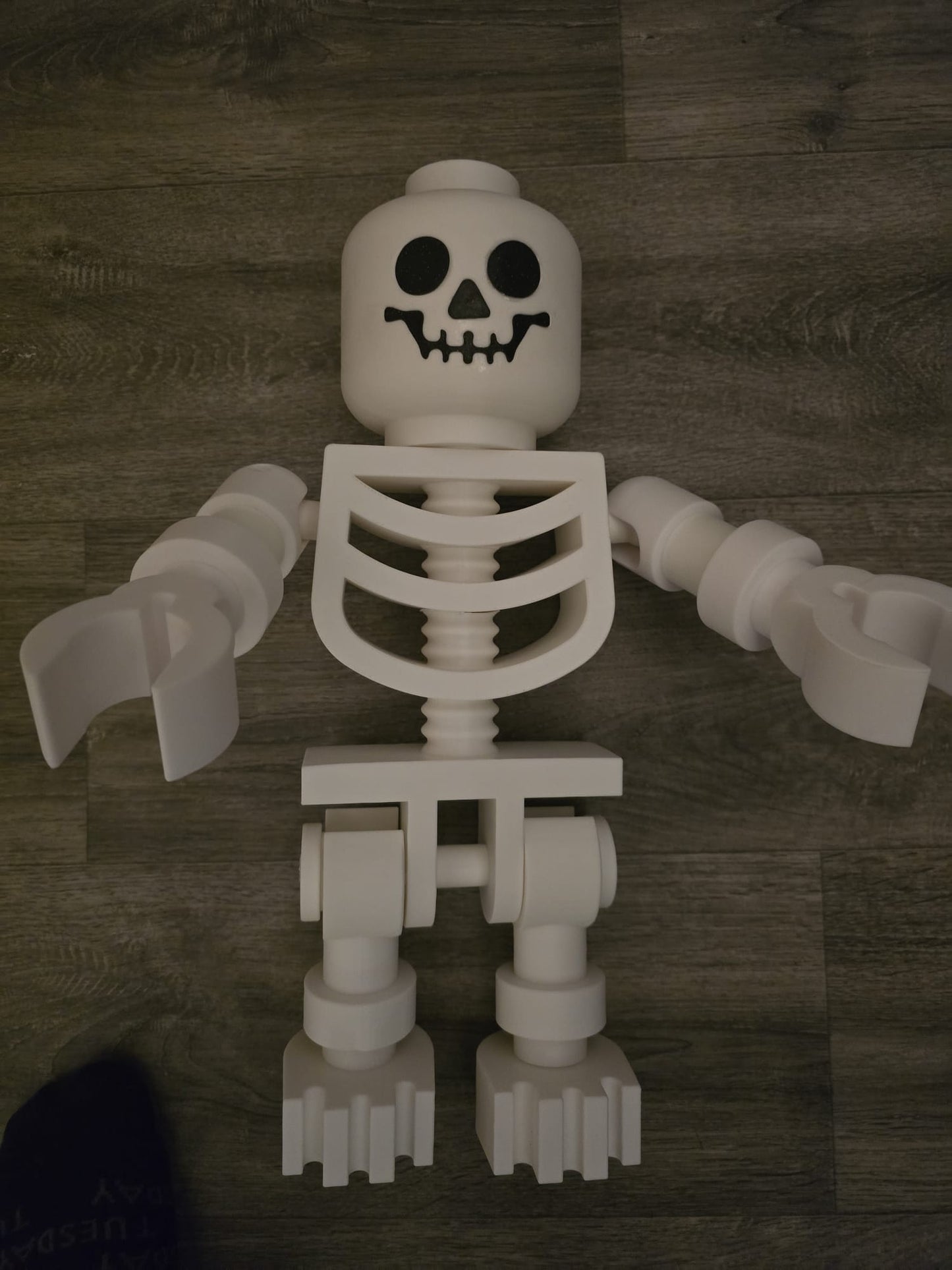 Oversized LEGO-style skeleton posed with Halloween props